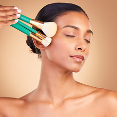 Image showing Makeup, face and brush with indian woman in studio for foundation, blush and self care. Glow, cosmetics and facial with female model with tool on brown background for shine, blusher and application