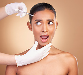 Image showing Woman, syringe and shock face in studio for cosmetic, surgery or wow for pain in forehead by background. Young, model and needle for facial skin, cosmetics and collagen filler for dermatology change