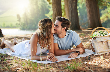 Image showing Couple kiss, love and picnic in forest, summer with freedom and adventure, relationship with affection and care outdoor. People together in nature park, commitment and trust with romance and bonding