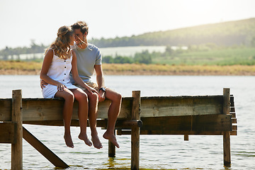 Image showing Couple sitting on jetty, relax by lake and summer, travel and adventure, love and care outdoor. People in relationship, trust and bonding on vacation, man and woman with freedom and forehead touch