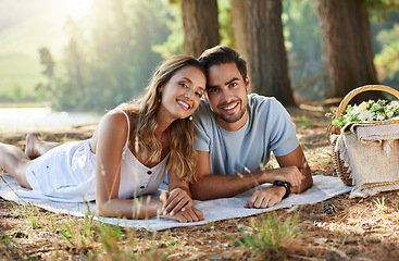 Image showing Couple on picnic, portrait and relax together in nature park, happy people with travel and bonding outdoor. Happiness, man and woman lying down and commitment with trust and love in relationship