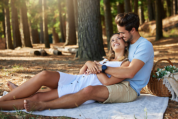 Image showing Couple on picnic, cuddle and happy relationship with love and trust, travel and adventure in nature park. Young people in forest, outdoor and happiness together with smile, commitment and care