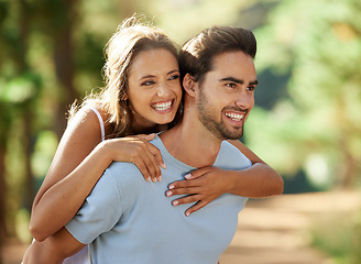 Image showing Couple in park, smile and piggy back, happy relationship with love and trust, travel and adventure in nature. Young people in forest, outdoor and happiness together with freedom, commitment and care