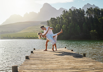 Image showing Love, lake and couple dancing together on the pier while on a romantic vacation, adventure or holiday. Romance, dance and young and and woman on a sidewalk in nature while on a summer weekend trip.