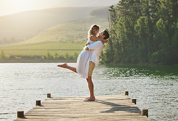 Image showing Couple, lake hug and engagement announcement of young people in love in nature. Happy, relax and happiness of woman and man together by water outdoor on summer vacation by a lakeside on holiday break