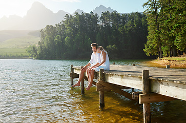 Image showing Love, happy and deck with couple at lake for bonding, romance and affectionate date. Nature, travel and holiday with man and woman cuddling on boardwalk in countryside for view, summer and vacation