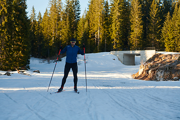 Image showing Nordic skiing or Cross-country skiing classic technique practiced by man in a beautiful panoramic trail at morning.Selective focus.