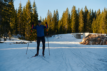 Image showing Nordic skiing or Cross-country skiing classic technique practiced by man in a beautiful panoramic trail at morning.Selective focus.