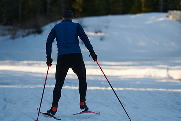 Image showing Nordic skiing or Cross-country skiing classic technique practiced by man in a beautiful panoramic trail at morning.Selective focus.