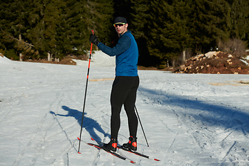 Image showing Nordic skiing or Cross-country skiing classic technique practiced by man in a beautiful panoramic trail at morning.Selective focus.