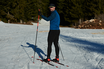 Image showing Nordic skiing or Cross-country skiing classic technique practiced by man in a beautiful panoramic trail at morning.Selective focus.