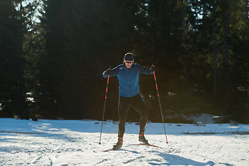 Image showing Nordic skiing or Cross-country skiing classic technique practiced by man in a beautiful panoramic trail at morning.Selective focus.