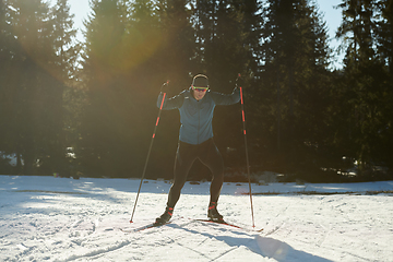 Image showing Nordic skiing or Cross-country skiing classic technique practiced by man in a beautiful panoramic trail at morning.Selective focus.