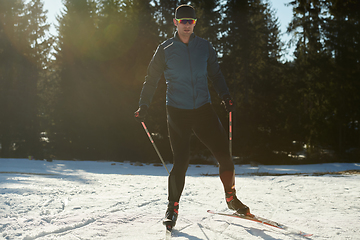 Image showing Nordic skiing or Cross-country skiing classic technique practiced by man in a beautiful panoramic trail at morning.Selective focus.