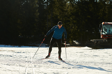 Image showing Nordic skiing or Cross-country skiing classic technique practiced by man in a beautiful panoramic trail at morning.Selective focus.