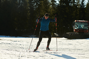 Image showing Nordic skiing or Cross-country skiing classic technique practiced by man in a beautiful panoramic trail at morning.Selective focus.