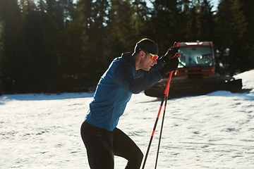 Image showing Nordic skiing or Cross-country skiing classic technique practiced by man in a beautiful panoramic trail at morning.Selective focus.