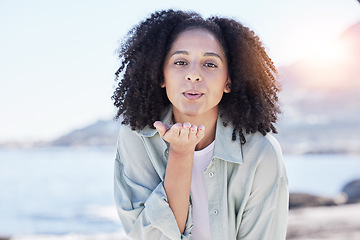 Image showing Woman at beach, portrait and blow kiss, love and freedom with travel, positive gesture and peace. Calm, happy and female person outdoor, young and carefree with emoji, care and romance with adventure