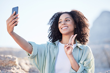 Image showing Woman at beach, selfie and peace hand sign, happy with travel and lifestyle influencer, photography and social media. Post, content creation and female person smile in picture outdoor with adventure