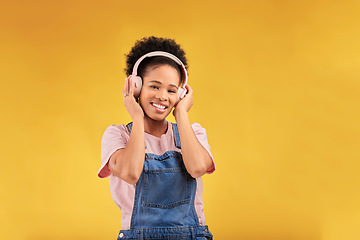 Image showing Headphones, music and black woman in portrait, smile and isolated in studio on a yellow background mockup space. Face, happy and person listening to radio, podcast or sound for jazz, hip hop or audio