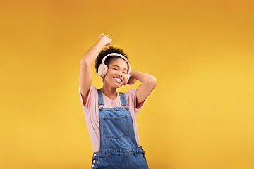 Image showing Music, headphones and happy black woman, dancing and isolated in studio on a yellow background mockup space. African person, smile and listening to radio, podcast or sound for jazz, hip hop or audio