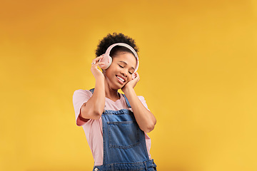 Image showing Music, headphones and happy black woman listening in studio isolated on a yellow background mockup space. African person, smile or hearing radio, podcast or sound for jazz, hip hop or streaming audio