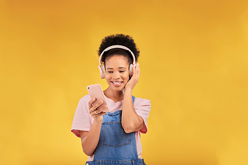 Image showing Happy, music and a black woman with a phone on a studio background for a podcast or audio. Smile, space and an African girl with headphones and a mobile for an app, streaming and listening to radio