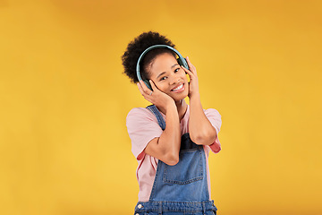 Image showing Music, headphones and happy black woman in portrait listening in studio isolated on a yellow background mockup space. Face, smile and person hearing radio, podcast or sound for jazz, hip hop or audio