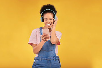 Image showing Online, music and a black woman with a phone on a studio background for a podcast or audio. Smile, space and an African girl with headphones and a mobile for an app, streaming and listening to radio