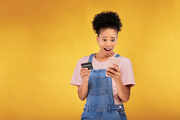 Image showing Woman, credit card and wow with phone, studio and shock face for deal, discount or sale by yellow background. Gen z girl, smartphone and banking with surprise for investment, scam and fintech app