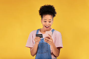 Image showing Woman, credit card and surprise with phone, studio and shock face for deal, discount or sales by yellow background. Gen z girl, cell phone and banking with wow for investment, smile and fintech app