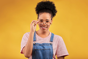 Image showing Portrait, glasses and happy with a black woman on a yellow background in studio for vision. Fashion, eyewear and smile with a young afro female nerd at the optometrist for prescription frame lenses