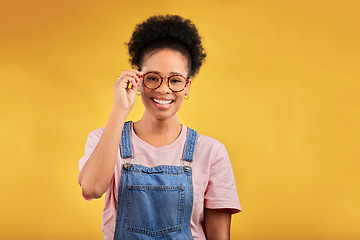 Image showing Portrait, glasses and smile with a black woman on a yellow background in studio for vision. Fashion, eyewear and a happy young afro female student at the optometrist for frame lenses or spectacles