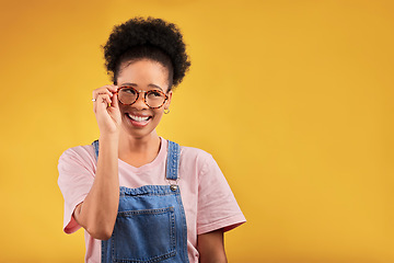 Image showing Smile, glasses and vision with a black woman nerd on a yellow background in studio for style. Fashion, eyewear and a happy young afro female geek at the optometrist for prescription frame lenses