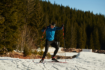 Image showing Nordic skiing or Cross-country skiing classic technique practiced by man in a beautiful panoramic trail at morning.Selective focus.