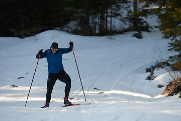 Image showing Nordic skiing or Cross-country skiing classic technique practiced by man in a beautiful panoramic trail at morning.Selective focus.