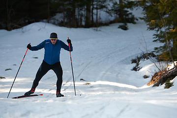 Image showing Nordic skiing or Cross-country skiing classic technique practiced by man in a beautiful panoramic trail at morning.Selective focus.