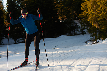 Image showing Nordic skiing or Cross-country skiing classic technique practiced by man in a beautiful panoramic trail at morning.Selective focus.