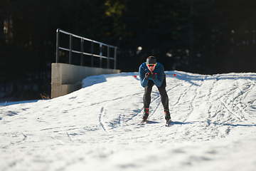 Image showing Nordic skiing or Cross-country skiing classic technique practiced by man in a beautiful panoramic trail at morning.Selective focus.