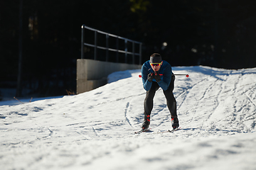 Image showing Nordic skiing or Cross-country skiing classic technique practiced by man in a beautiful panoramic trail at morning.Selective focus.