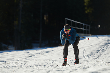 Image showing Nordic skiing or Cross-country skiing classic technique practiced by man in a beautiful panoramic trail at morning.Selective focus.