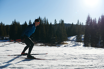 Image showing Nordic skiing or Cross-country skiing classic technique practiced by man in a beautiful panoramic trail at morning.Selective focus.