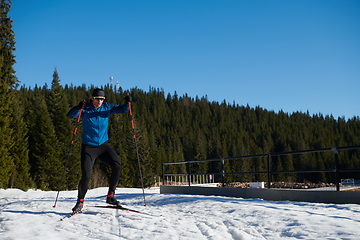 Image showing Nordic skiing or Cross-country skiing classic technique practiced by man in a beautiful panoramic trail at morning.Selective focus.