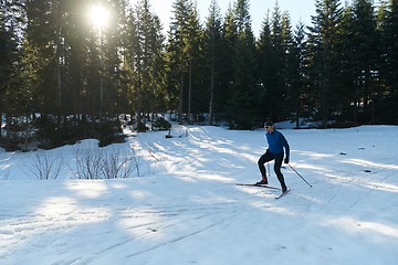 Image showing Nordic skiing or Cross-country skiing classic technique practiced by man in a beautiful panoramic trail at morning.Selective focus.