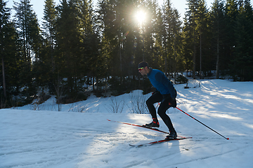 Image showing Nordic skiing or Cross-country skiing classic technique practiced by man in a beautiful panoramic trail at morning.Selective focus.