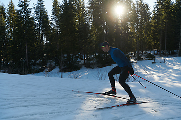 Image showing Nordic skiing or Cross-country skiing classic technique practiced by man in a beautiful panoramic trail at morning.Selective focus.