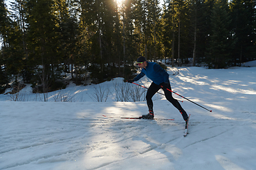 Image showing Nordic skiing or Cross-country skiing classic technique practiced by man in a beautiful panoramic trail at morning.Selective focus.