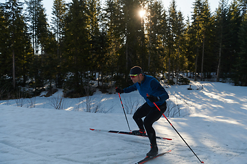 Image showing Nordic skiing or Cross-country skiing classic technique practiced by man in a beautiful panoramic trail at morning.Selective focus.