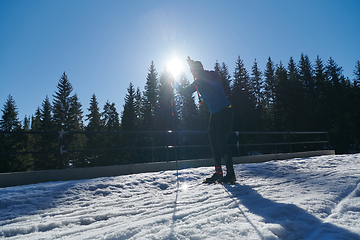 Image showing Nordic skiing or Cross-country skiing classic technique practiced by man in a beautiful panoramic trail at morning.Selective focus.