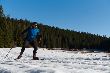 Image showing Nordic skiing or Cross-country skiing classic technique practiced by man in a beautiful panoramic trail at morning.Selective focus.